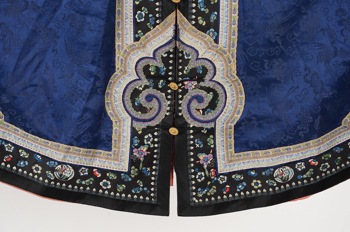 A late 19th century Chinese blue silk damask jacket, woven with Phoenix and auspicious symbols. The jacket edged with ornate rows of braiding and silk embroidery, the interior with original pink silk lining. The jacket f